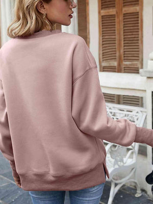 a woman wearing a pink sweatshirt and jeans