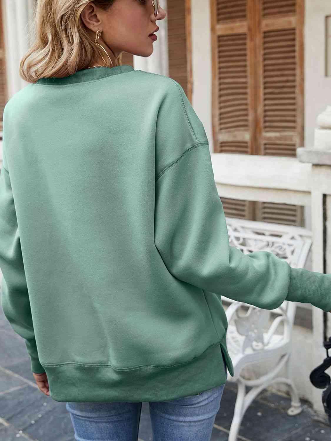 a woman wearing a green sweatshirt and jeans