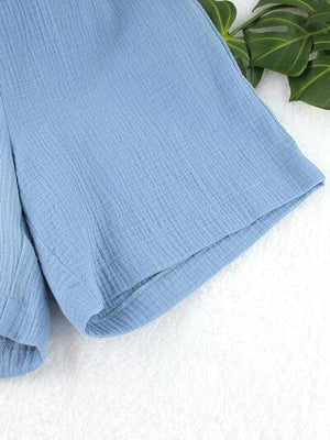 a pair of blue shorts laying on top of a white blanket