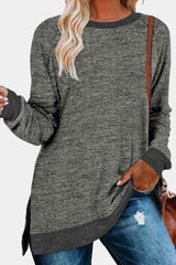 a woman wearing a grey sweater and ripped jeans