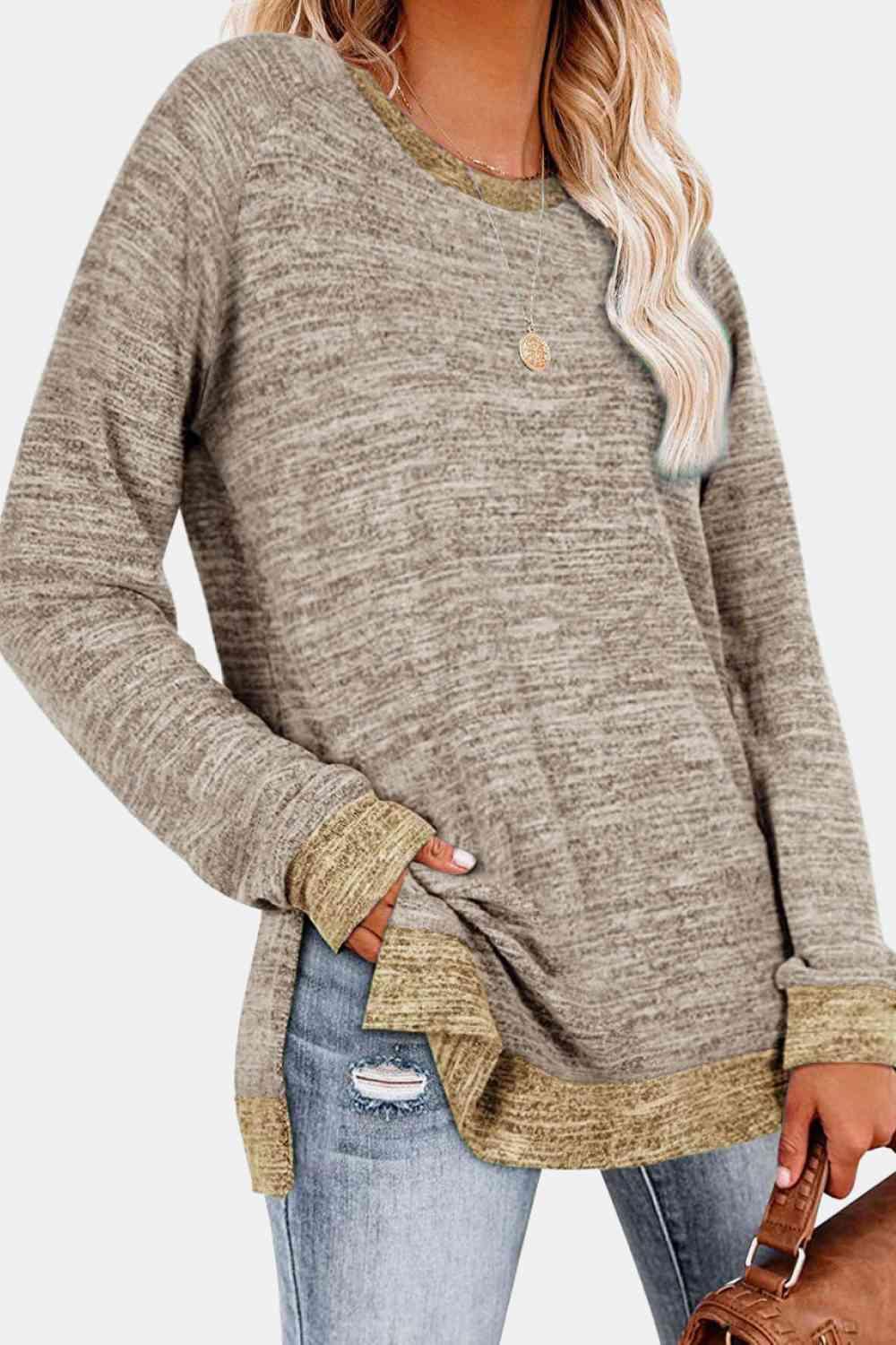 a woman wearing a brown sweater and ripped jeans