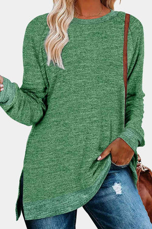 a woman wearing a green sweater and ripped jeans