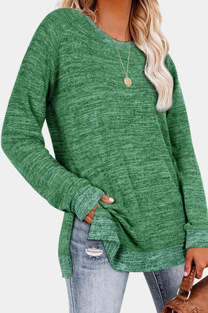 a woman wearing a green sweater and ripped jeans