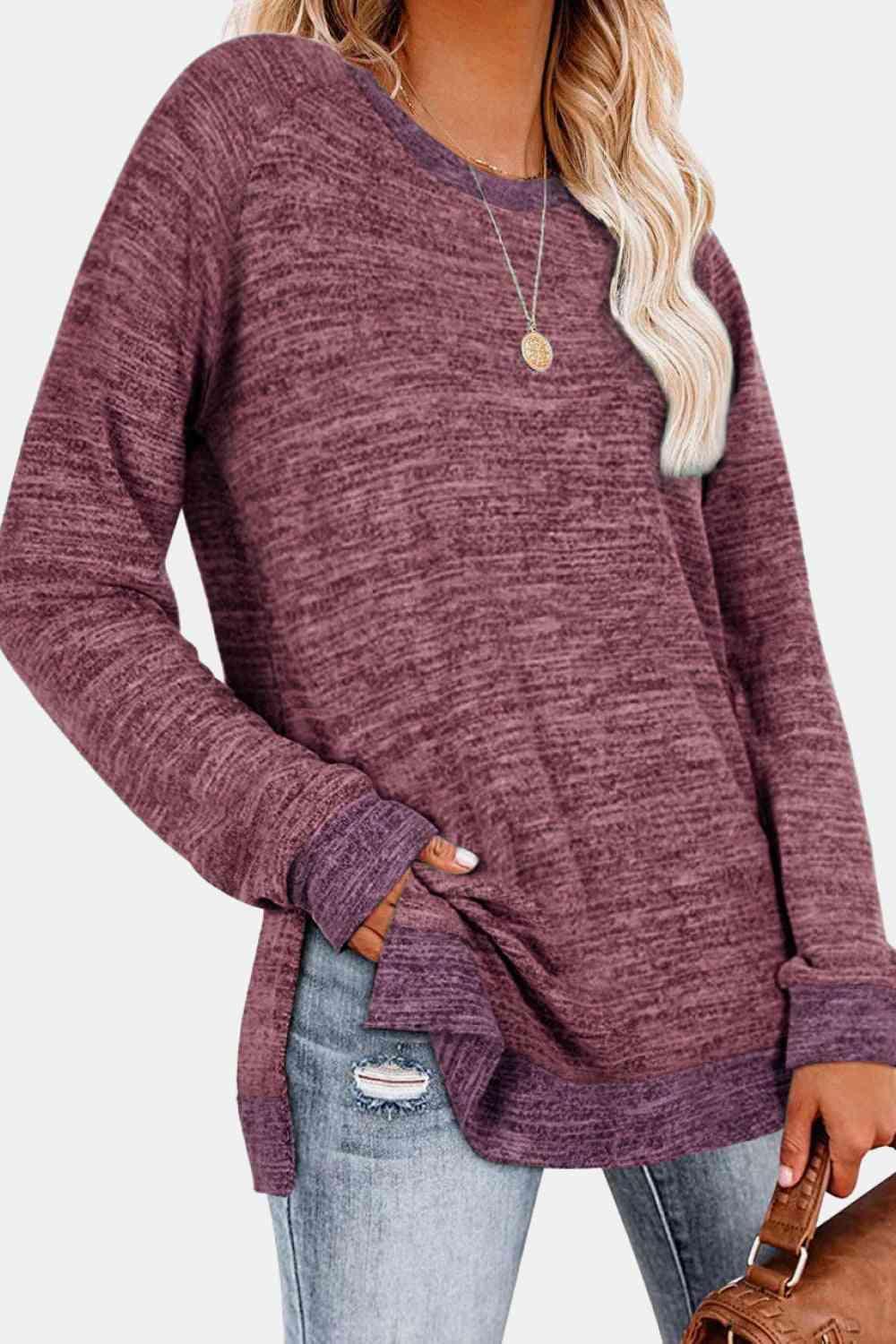 a woman wearing a purple sweater and ripped jeans