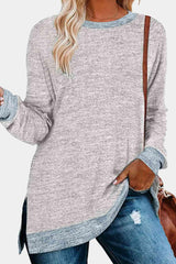 a woman wearing a grey sweater and ripped jeans