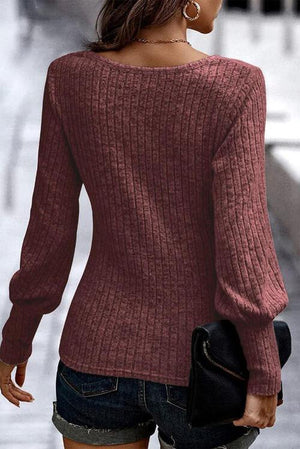 a woman walking down a street wearing a red sweater