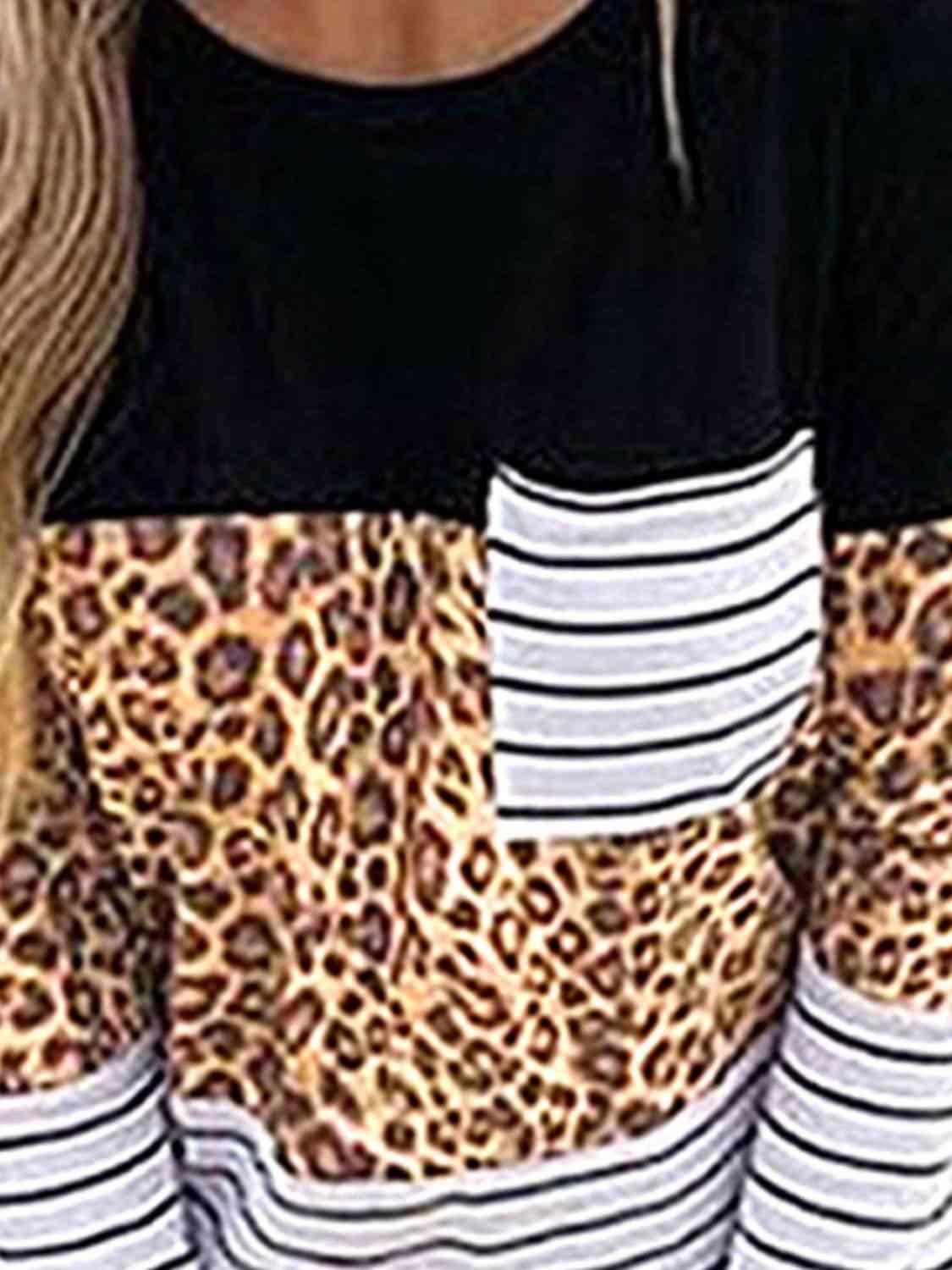 a woman wearing a black and white top with a leopard print pocket