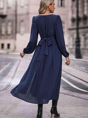 a woman in a blue dress walking down a street