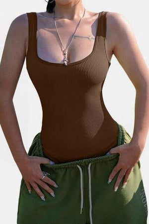 a woman wearing a brown tank top and green shorts