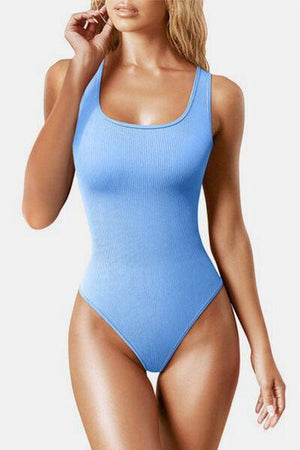 a woman in a blue bodysuit posing for a picture