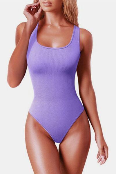 a woman in a purple bodysuit posing for a picture