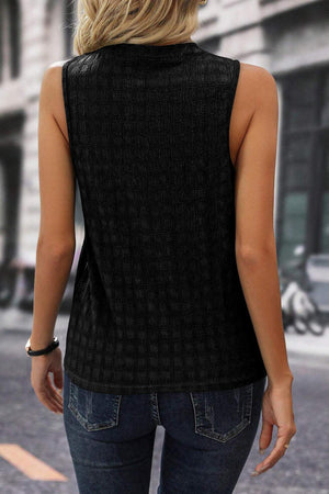 a woman standing on the street wearing a black top