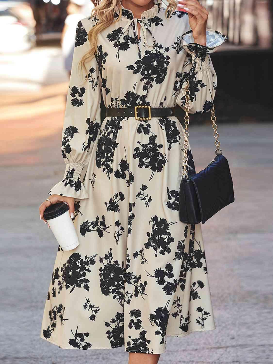 a woman in a floral dress smoking a cigarette