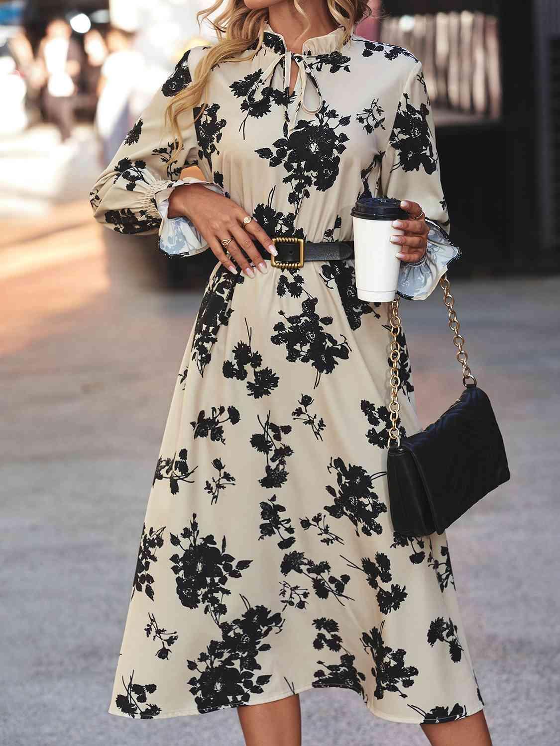 a woman in a black and white dress holding a cup of coffee