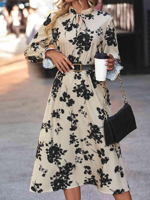 a woman in a black and white dress holding a cup of coffee