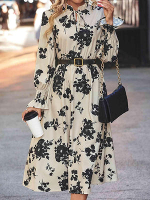 a woman in a floral dress smoking a cigarette