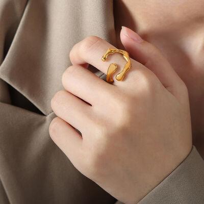 a woman wearing a gold ring with a curved design