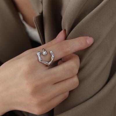 a woman wearing a ring with a heart on it