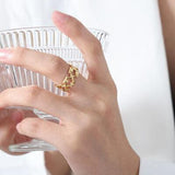 a woman holding a glass with a gold ring on it