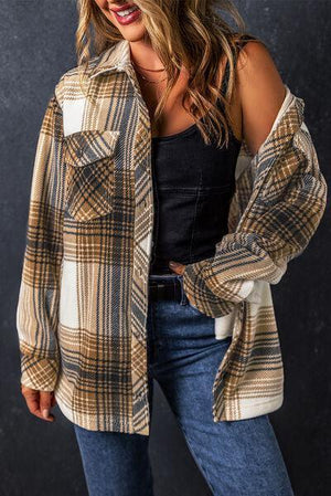 a woman wearing a plaid jacket and jeans