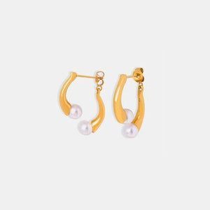 a pair of gold hoop earrings with pearls