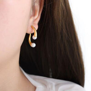 a close up of a person wearing a pair of earrings