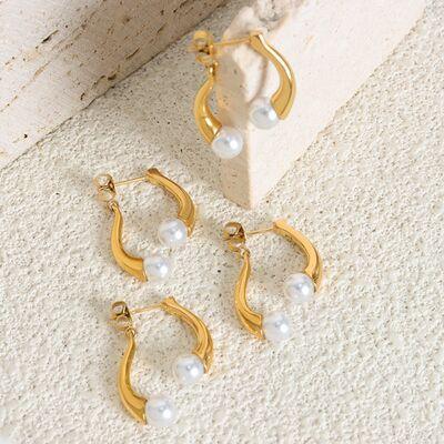 a pair of gold hoop earrings with pearls