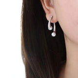 a close up of a person wearing a pair of earrings