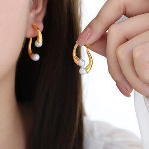 a close up of a person holding a pair of earrings