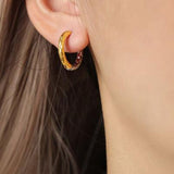 a close up of a person wearing a pair of earrings