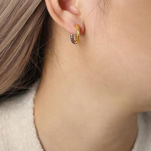 a close up of a person wearing a pair of earrings