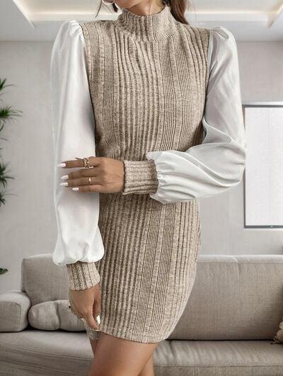 a woman standing in a living room wearing a sweater dress