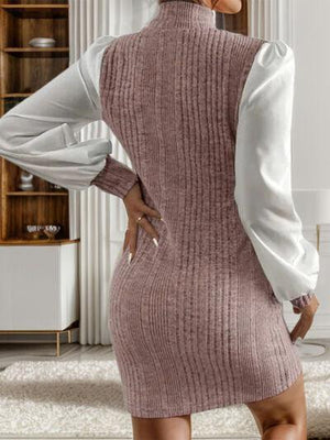 a woman standing in a living room wearing a sweater dress
