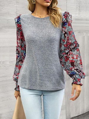 a woman wearing a gray top with floral sleeves