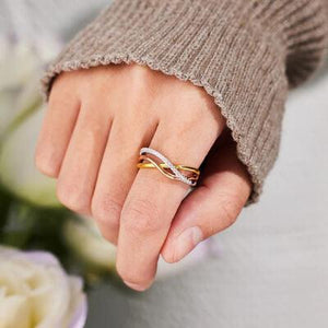 a close up of a person's hand holding a wedding ring