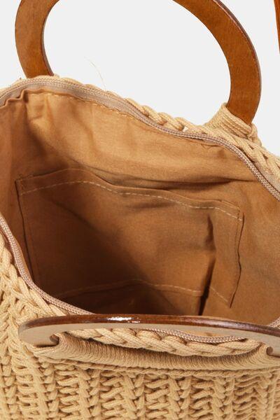 a straw bag with a wooden handle on a white background