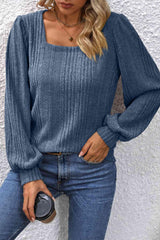 a woman wearing a blue sweater and jeans