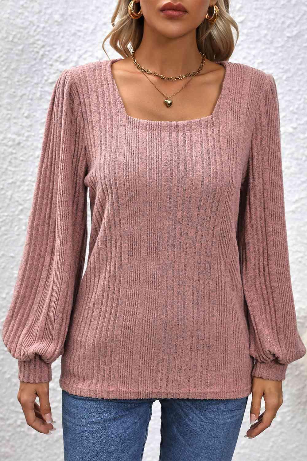 a woman wearing a pink sweater and jeans