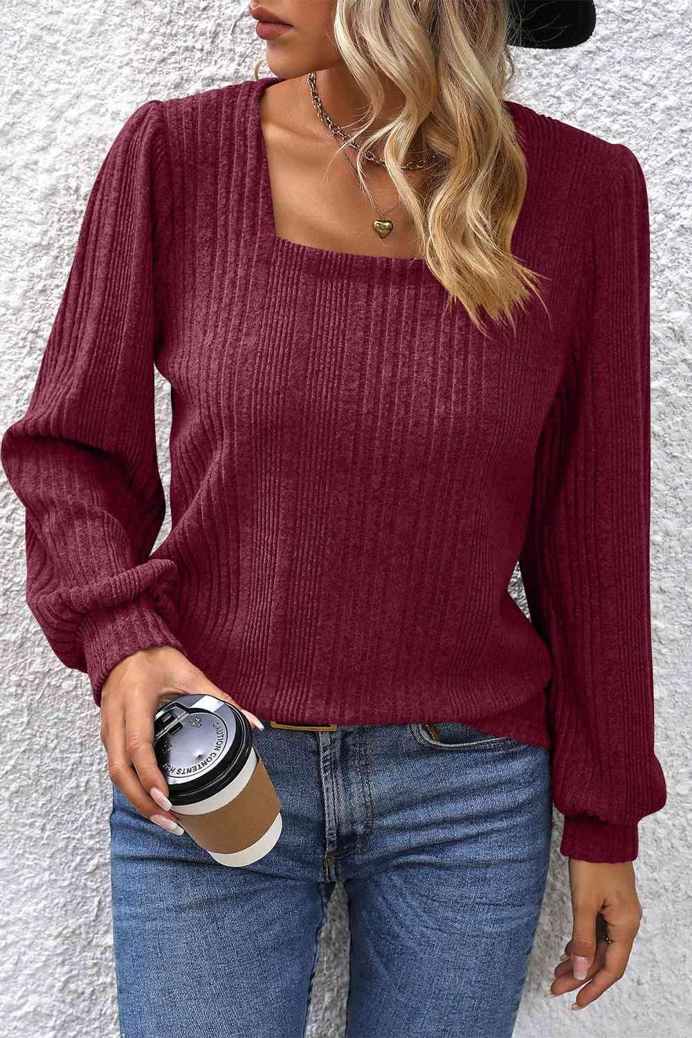 a woman wearing a burgundy sweater and jeans