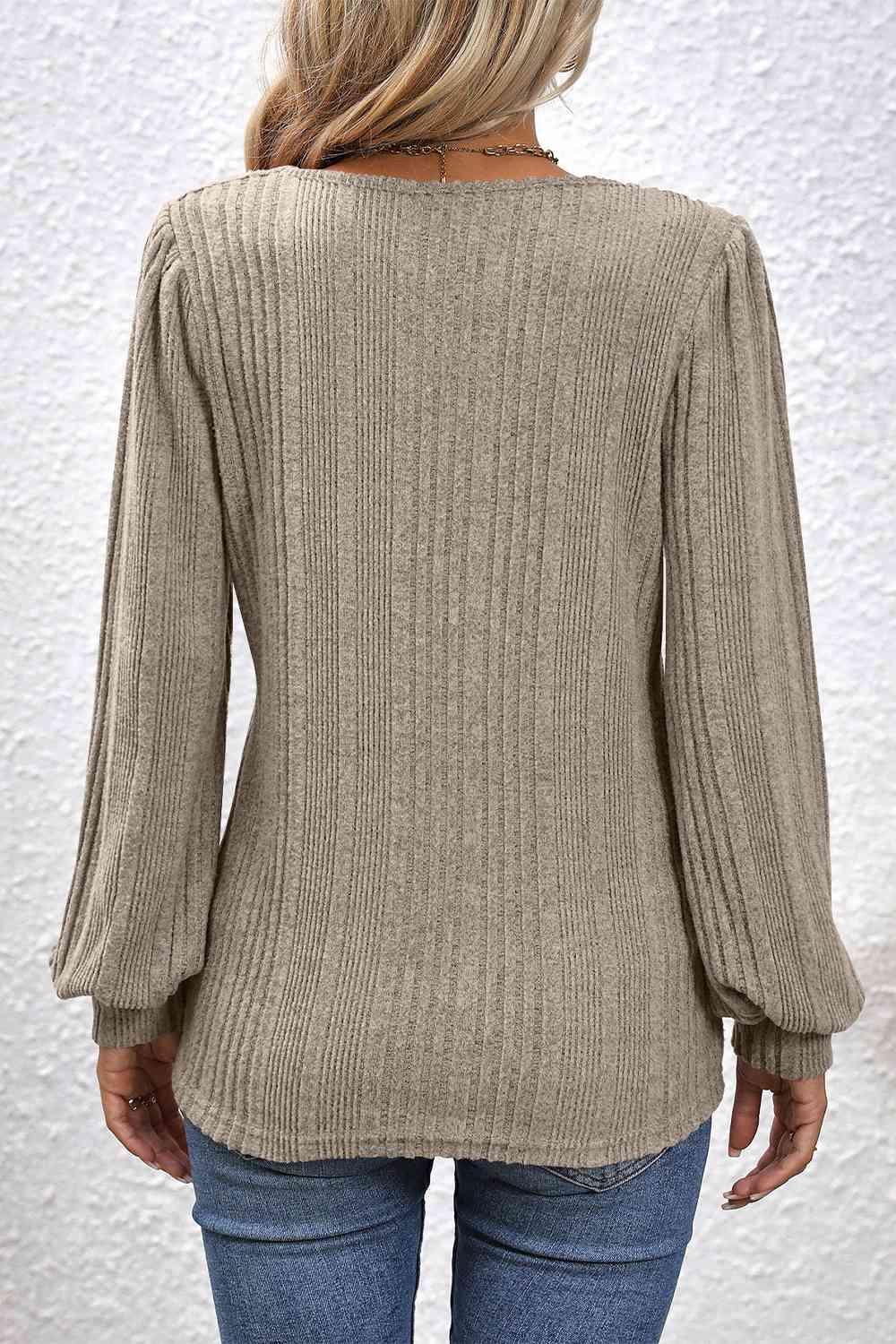 a woman wearing a tan sweater and jeans