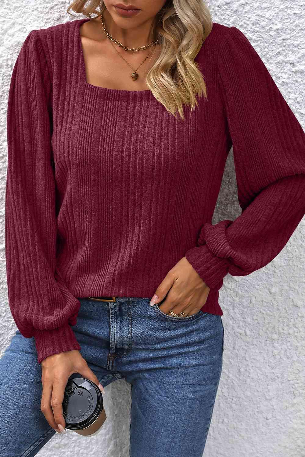 a woman wearing a red sweater and jeans