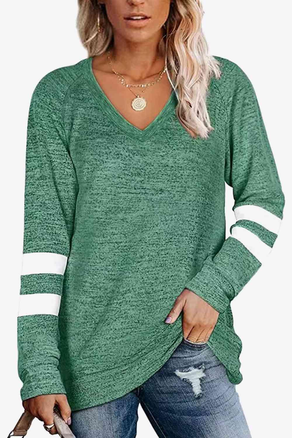 a woman wearing a green sweater with white stripes