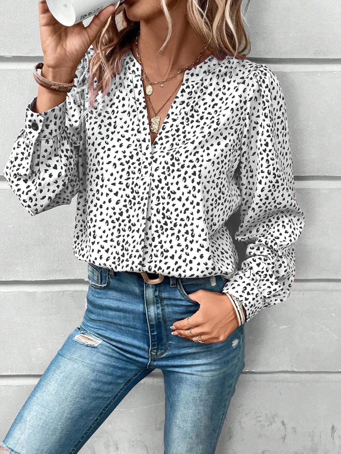 a woman wearing a leopard print shirt and jeans