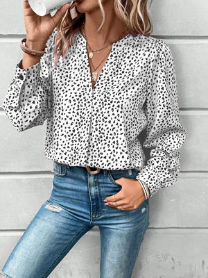 a woman wearing a leopard print shirt and jeans