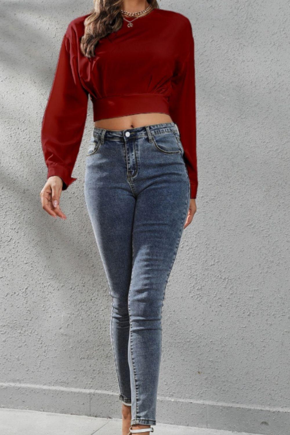 a woman wearing a red top and jeans