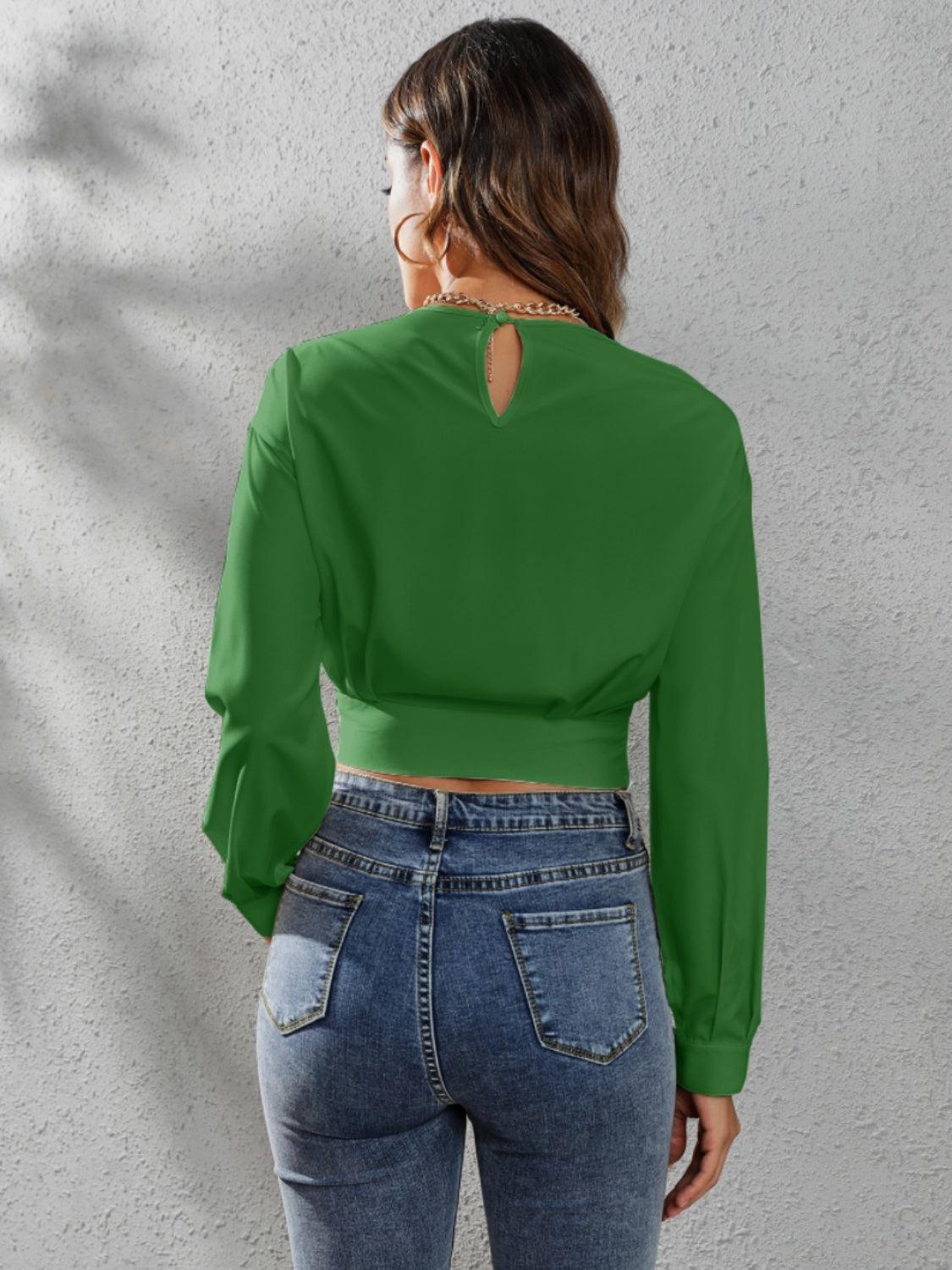 a woman wearing a green blouse and jeans