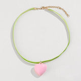 a pink heart on a green cord necklace