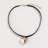 a black cord necklace with a gold heart pendant