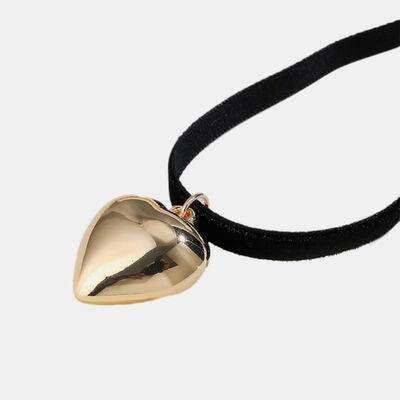 a necklace with a gold bell on a black cord