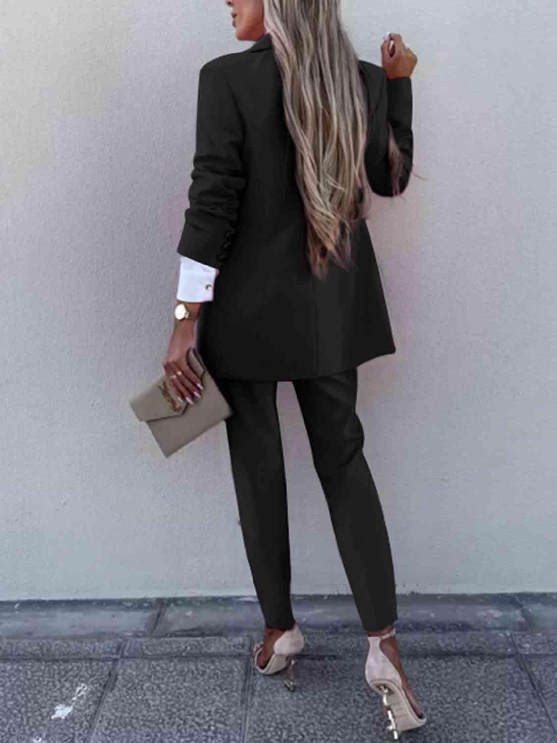 a woman wearing a black suit and heels